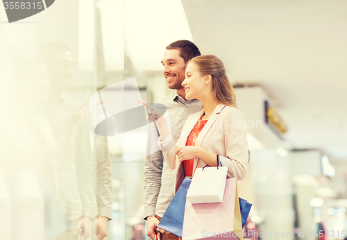 Image of happy young couple with shopping bags in mall