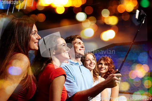 Image of friends with smartphone taking selfie in club