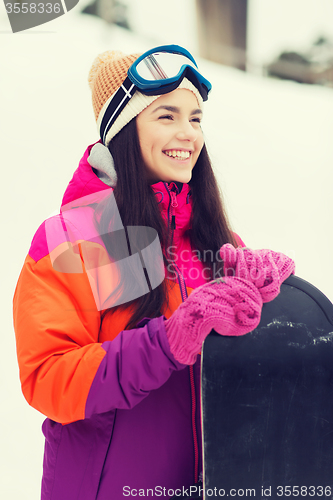 Image of happy young woman with snowboard outdoors