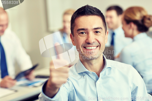 Image of group of smiling businesspeople meeting in office