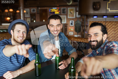 Image of happy male friends drinking beer at bar or pub