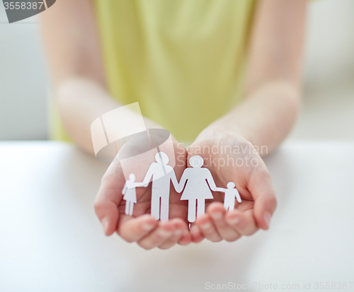 Image of close up of child hands with paper family cutout