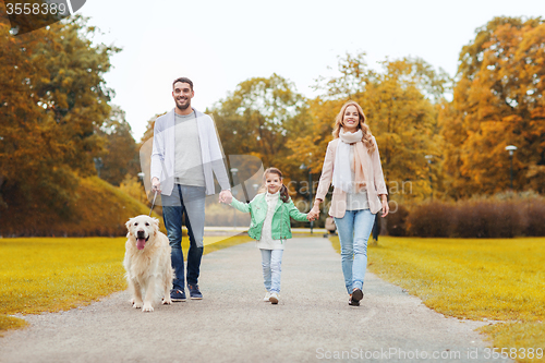 Image of happy family with labrador retriever dog in park