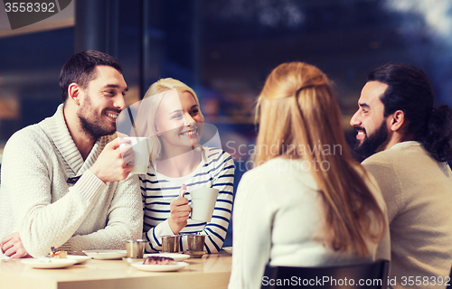 Image of happy friends meeting and drinking tea or coffee