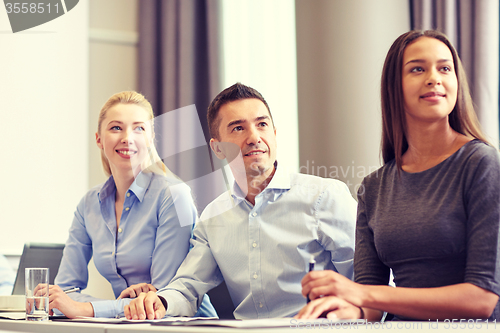 Image of group of smiling businesspeople meeting in office