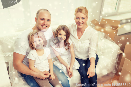 Image of smiling parents and two little girls at new home