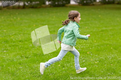 Image of happy little girl running on green summer field