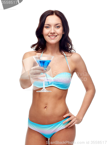 Image of happy young woman in swimsuit drinking cocktail