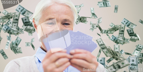 Image of close up of happy senior woman playing cards