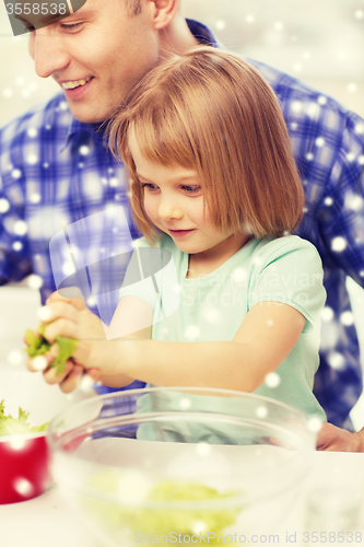 Image of happy father with girl making dinner at home