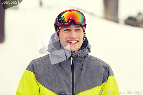 Image of happy young man in ski goggles outdoors