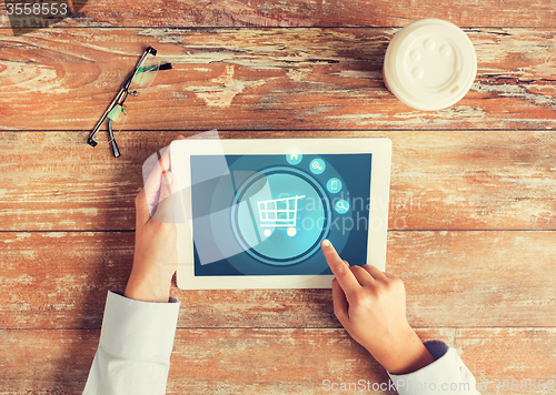 Image of close up of hands with tablet pc and shopping cart