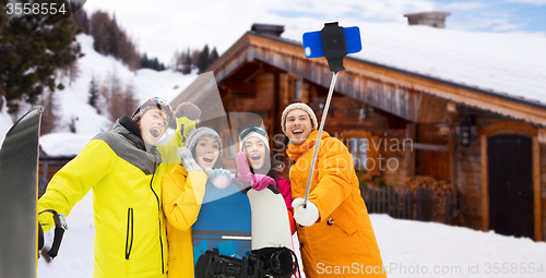 Image of happy friends with snowboards and smartphone