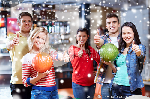 Image of happy friends in bowling club showing thumbs up