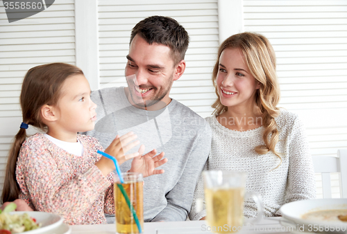 Image of happy family having dinner at restaurant or cafe