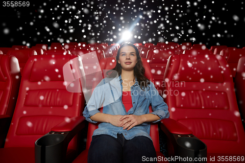 Image of young woman watching movie in theater