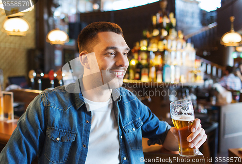 Image of happy man drinking beer at bar or pub