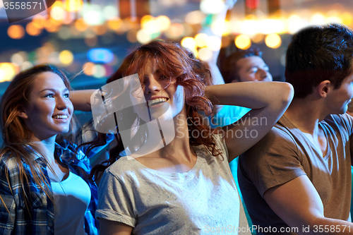 Image of happy friends dancing at night club