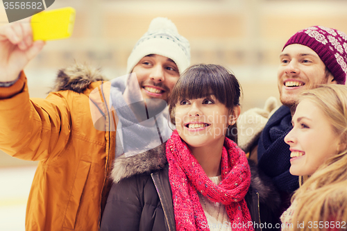 Image of happy friends taking selfie on skating rink