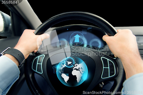 Image of close up of man driving car with globe on screen