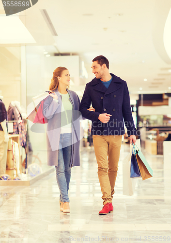 Image of happy young couple with shopping bags in mall