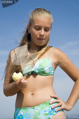 Image of Girl eating apple on the beach II