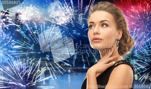 Image of beautiful woman wearing earrings over firework