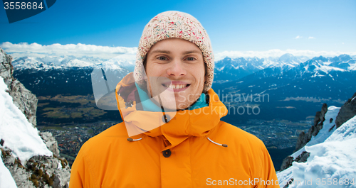 Image of happy young man in winter clothes outdoors