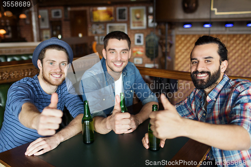 Image of happy male friends drinking beer at bar or pub