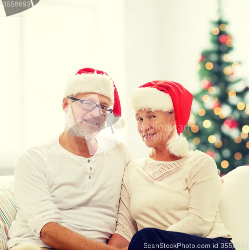 Image of happy senior couple in santa helper hats