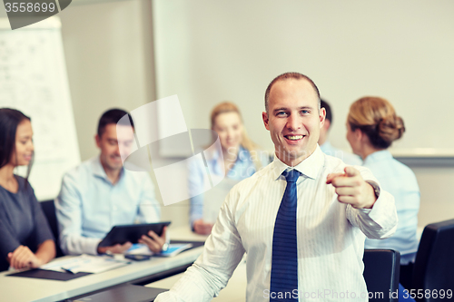 Image of group of smiling businesspeople meeting in office