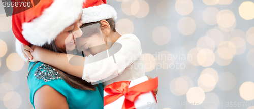 Image of happy mother and little girl in santa hats