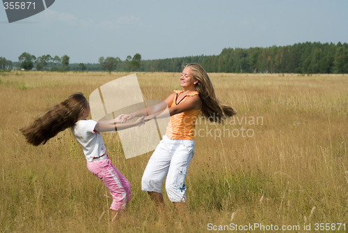 Image of Girls plays on a meadow