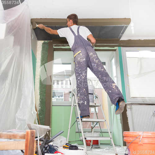 Image of Plasterer renovating indoor walls and ceilings.