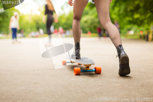 Image of Teenage girl urban long board riding.