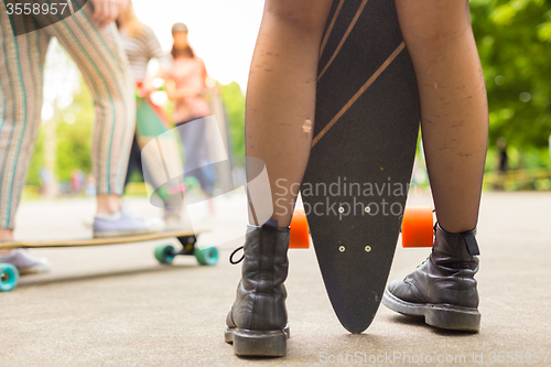 Image of Teenage girl urban long board riding.