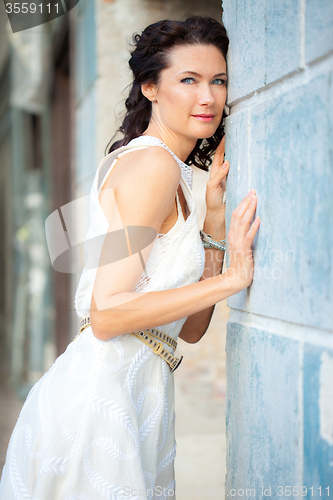 Image of woman in a white dress near the old stone wall