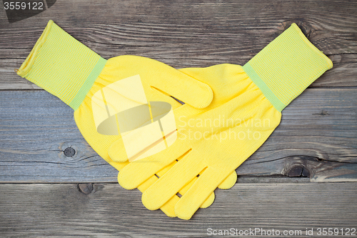 Image of handshake yellow construction gloves