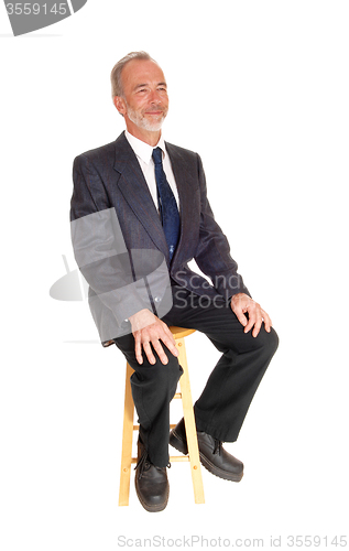 Image of Middle age professional man sitting on a chair.