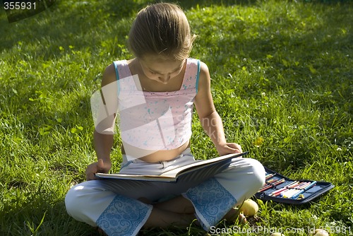 Image of The girl draws on a meadow