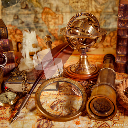 Image of Vintage magnifying glass lies on an ancient world map