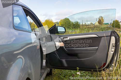Image of Human hand opens the car door In the countryside