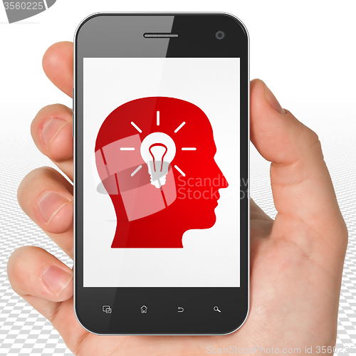 Image of Advertising concept: Hand Holding Smartphone with Head With Light Bulb on display