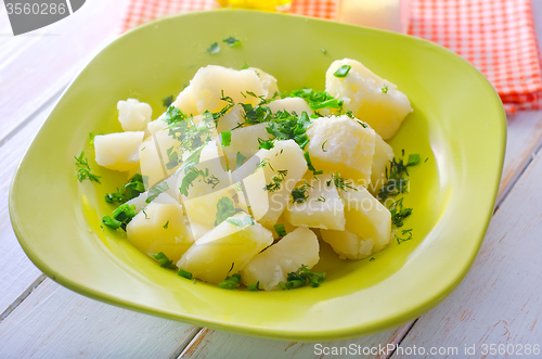 Image of boiled potato with greens in the green plate