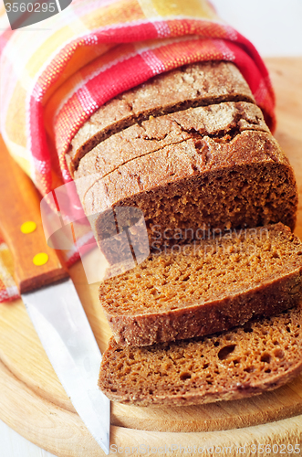 Image of Fresh bread and knife on the wooden board