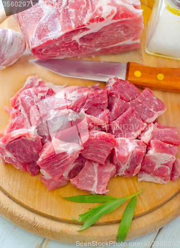 Image of raw meat and knife on the wooden board