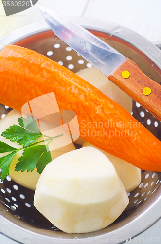 Image of Raw potato and carrot in the metal bowl