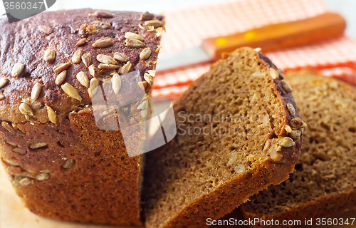 Image of Fresh bread and knife on the wooden board