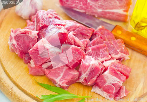 Image of raw meat and knife on the wooden board