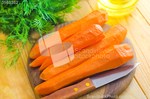 Image of raw carrots and knife on the wooden board